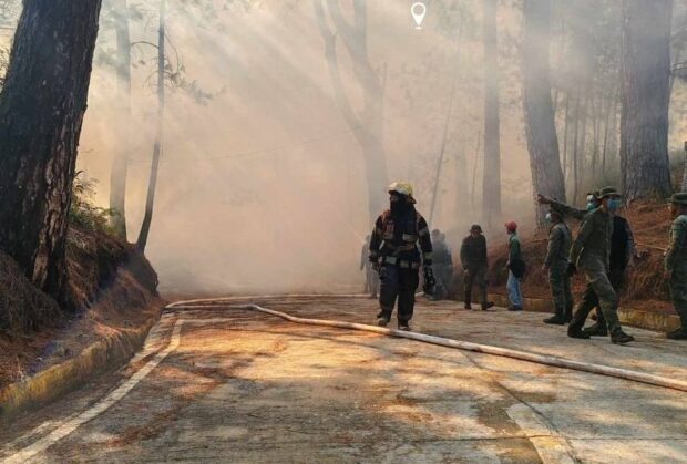 PHOTO: Baguio City firemen wear face masks and proper gear as they try to put out a fire that hit a mountain near the Philippine Military Academy on Wednesday, February 21, 2024. STORY: Baguio City health alert up as forest fires rage
