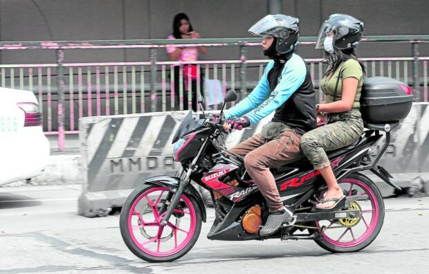 PHOTO: A motorcycle taxi ferries a passenger in Mandaluyong City amid plans to grant them a public transportation franchise. STORY: Speaker pushes law on motorcycle taxis