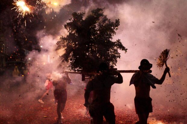 PHOTO: Men hoist a palanquin bearing the figure of fortune god Master Han Dan as they walk through a bombardment of firecrackers. STORY: Taiwan lobs firecrackers at deity for good fortune