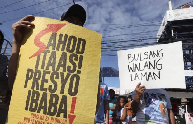 APPEAL FROMTHE POOR Members of urban poor groups, in this January 2023 photo, stage a protest in front of Commonwealth Market in Quezon City to air their appeal for an increase in daily wage amid the soaring food prices. —NIÑO JESUS ORBETA
