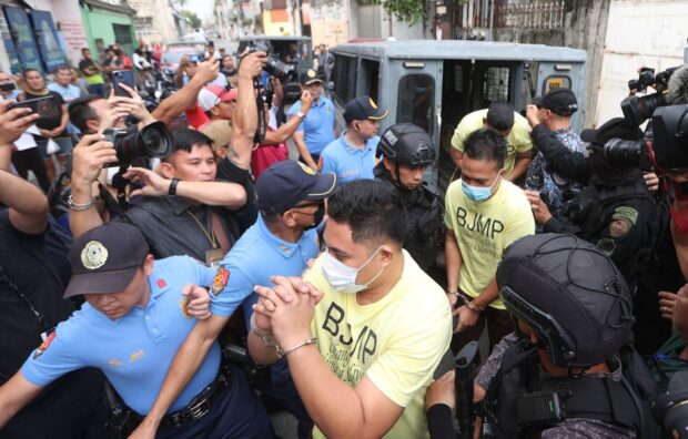 ACCUSED Wearing prison shirts and in handcuffs, the police officers accused of shooting and killing Jerhode “Jemboy” Baltazar in August last year arrive at Navotas City Regional Trial Court on Tuesday. —NIÑO JESUS ORBETA