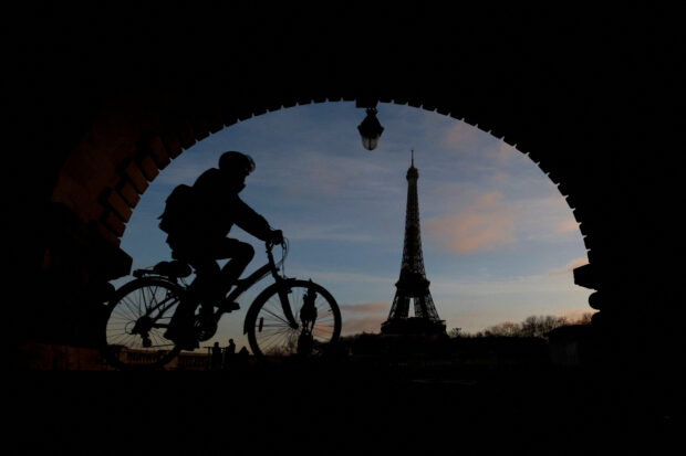 A man rides a bicycle along a bike path on the Pont de Bir-Hakeim bridge near the Eiffel Tower in Paris during a nationwide day of strike and protests against the French government’s pension reform plan in France, January 19, 2023.