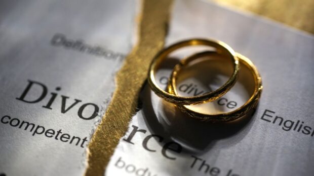 PHOTO: Stock image wedding rings on top open book with partially covered book with the word “divorce.” STORY: World Bank: Divorce law to boost women’s economic role