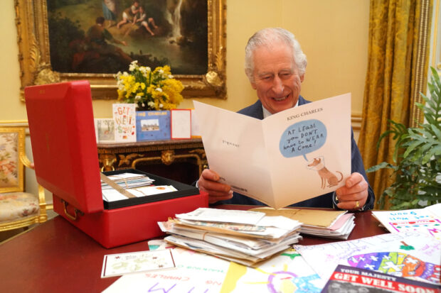 Britain's King Charles reads cards and message, in London