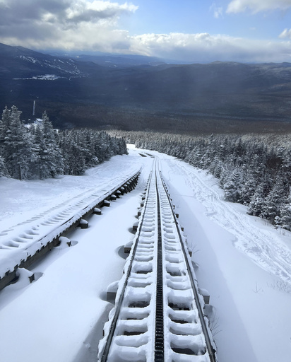 In this image provided by New Hampshire Fish and Game, snow covers the rails on the train tracks leading to the summit Mount Washington above the Cog Railway base station, Saturday, Feb. 17, 2024, in Mount Washington, N.H. A team of rescuers used the Cog Railway to shave off time but it still took more than 10 hours to save a hiker in conditions that included sustained winds topping 90 mph (145 kph) on New Hampshire's Mount Washington, officials said. (Conservation Officer Brad Jones/New Hampshire Fish and Game via AP)