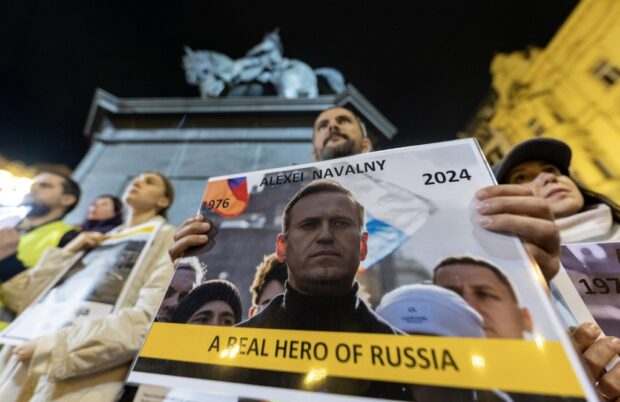 People hold portraits of the late Russian opposition leader Alexei Navalny