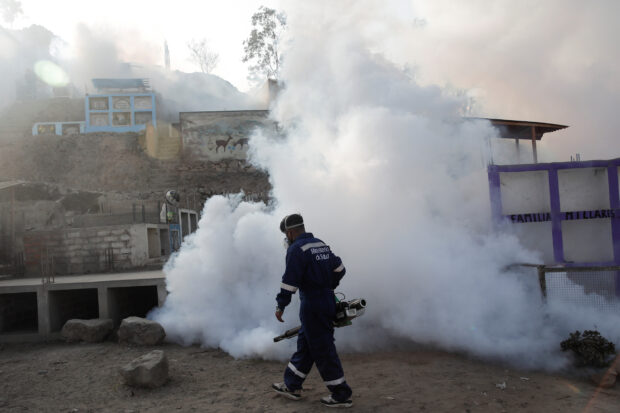A health worker sprays fumigation vapour to stem the spread of dengue virus, in Lima