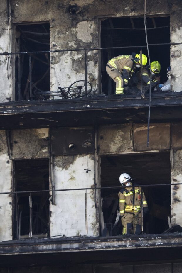 Firefighters proceed to remove the body of a victim of the huge fire that yesterday raged through a multistorey residential block killing at least four people, in Valencia on February 23, 2024
