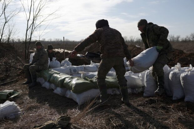 Ukrainian servicemen pile up earthbags to build a fortification not far from town of Avdiivka in the Donetsk region