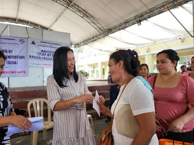 In this undated photo provided by the Quezon City government, Mayor Joy Belmonte gives social welfare assistance to 657 indigent solo parents.