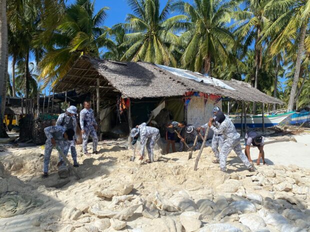 Authorities dig up giant clams on the shores of Balabac town in Palawan province on February 14, 2024. PHOTO FROM THE PHILIPPINE COAST GUARD