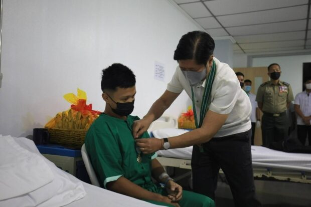 PHOTO: Ferdinand Marcos Jr. pins a medal on a wounded soldiers. STORY: Marcos honors 4 soldiers wounded in clash with terrorists