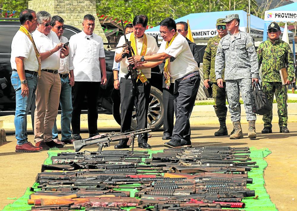 President Marcos examines a surrendered rifle before its destruction inBasilan