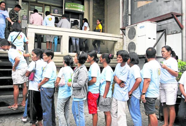 PHOTO: Beneficiaries queue up to get their monthly doles from automated teller machines. STORY: Senator Pimentel urges review of cash aid programs