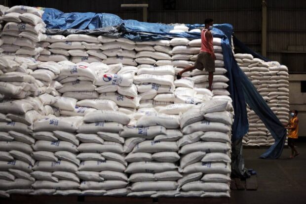 PHOTO: In this photo taken in November 2020, workers at the National Food Authority warehouse in Quezon City ensure that the government’s rice stocks are properly stored. STORY: NFA chief, 138 employees suspended over rice row