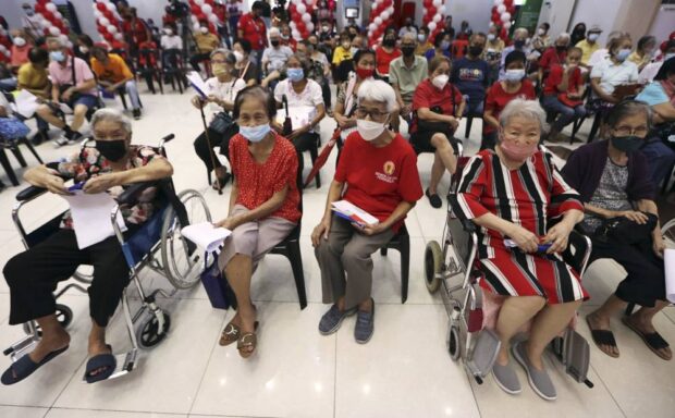 PHOTO: Senior citizens sitting down in chairs in a hall. STORY: DTI sets consultations on senior citizen, PWD discounts
