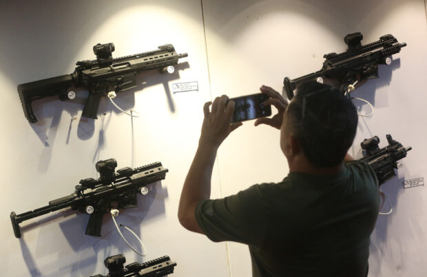 PHOTO: A gun enthusiast check out the various types of firearms on display at a weapons trade exhibition organized by Armscor Global Defense Inc. at SM Megamall in Mandaluyong City, in this photo taken on June 23, 2023 STORY: Eased policy on civilian gunownership triggers concerns