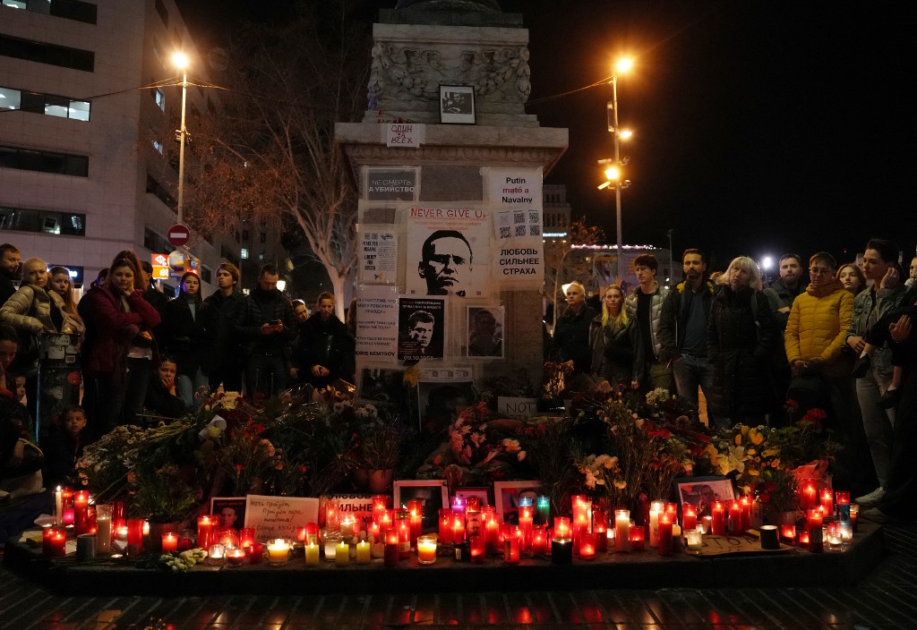 People gather around at a makeshift memorial to pay tribute to the Russian opposition leader Alexei Navalny in Barcelona 