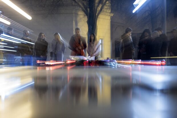 Pessoas acendem velas em um memorial improvisado de flores e velas em homenagem ao líder da oposição russa Alexei Navalny em Zagreb