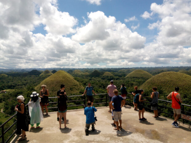 Tourists get a perfect view of the Chocolate Hills, Bohol’s top natural attraction and a declared natural monument, from a view deck in Carmen town in this photo taken in 2017. STORY: ‘Defacement’ of protected sites sparks call for Senate inquiry