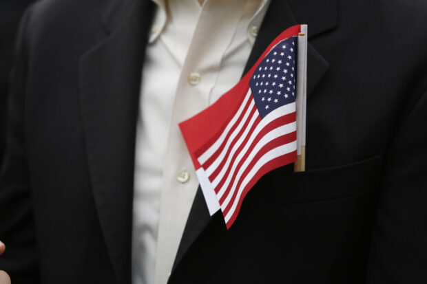 A guest wears U.S. and Singapore flags prior to arrival ceremony at the White House in Washington