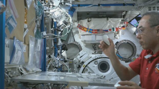 Astronaut Furukawa repeatedly throws the oloid in microgravity to test its movement. (Photo and caption courtesy of the National Aeronautics and Space Administration/Japan Aerospace Exploration Agency)