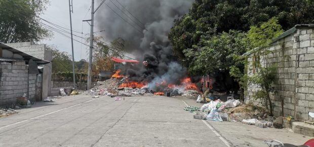 The road leading to SitIo Balubad in Anunas village, Angeles City is blocked by burning tires and other objects to prevent the demolition team from entering the sub-village in this photo taken on Tuesday.