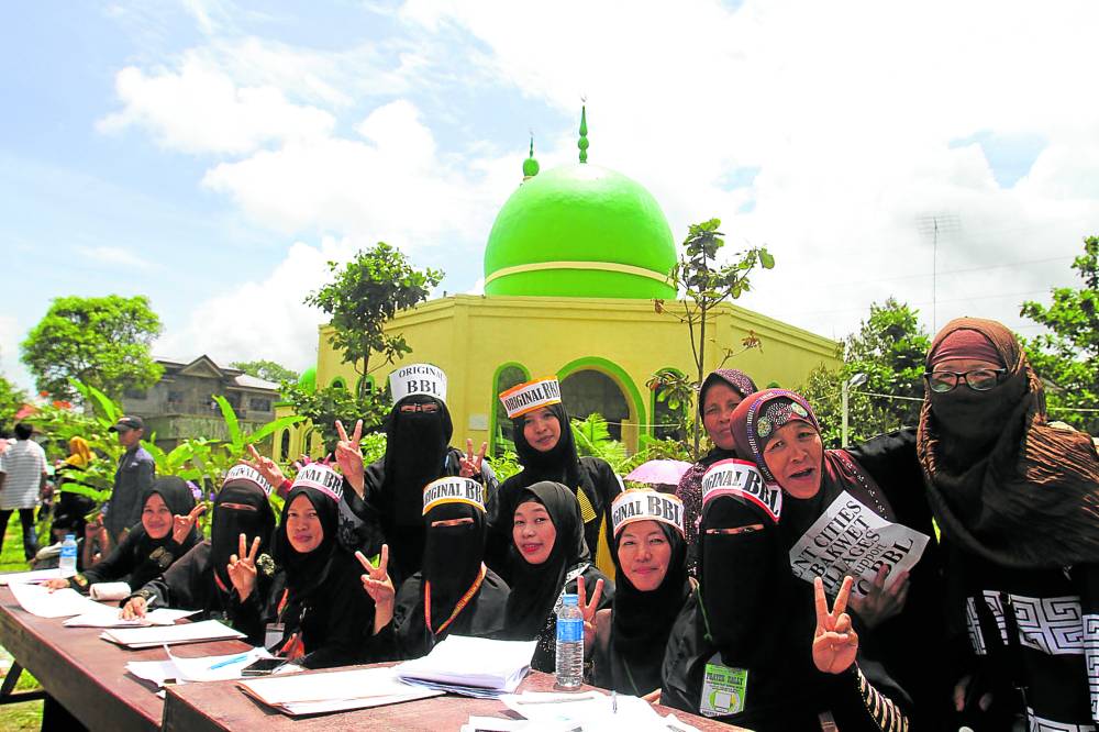 Maranao women (left photo) join a rally in 2018 to push for the enactment by Congress of the lawthat will give birth to the Bangsamoro autonomous region.