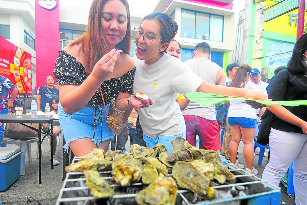 DELICACY Visitors get totaste grilled oysters and other dishes using this delicacy during the recent festival.