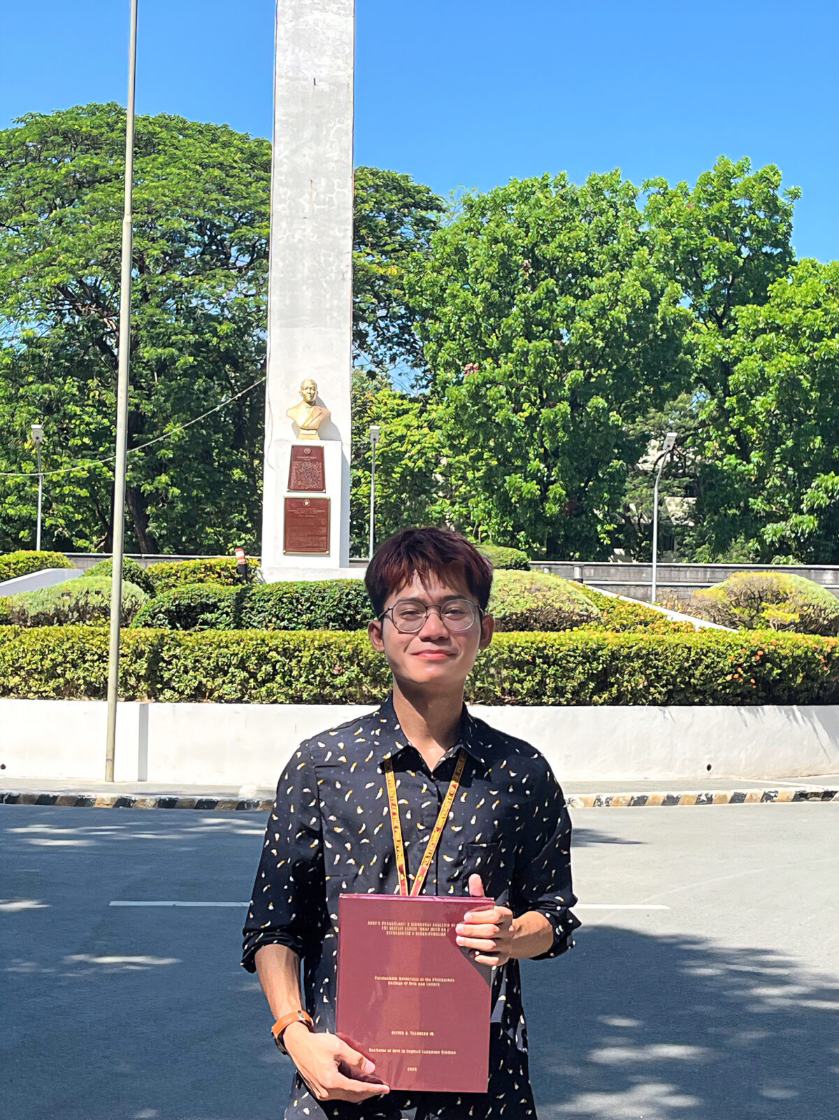 Oliver Tesorero holding the hardbound copy of his thesis at The Obelisk in PUP. Photo courtesy of Oliver Tesorero