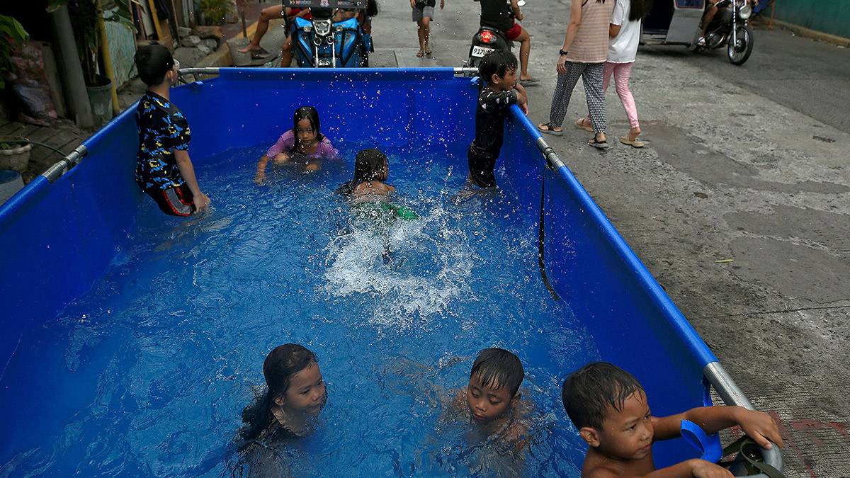 BEATING THE HEAT Children at a neighborhood at Blumentritt Road in Manila cool off at an inflatable pool on Sunday. —RICHARD A. REYES
