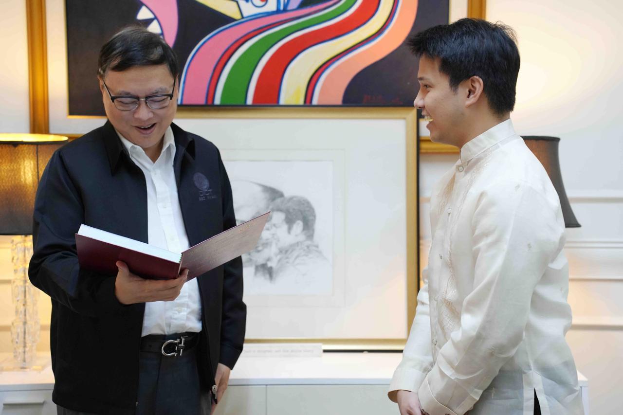 Dr. Brian Poe-Llamanzares gives DICT Secretary Ivan Uy a copy of his dissertation on the National Broadband Plan