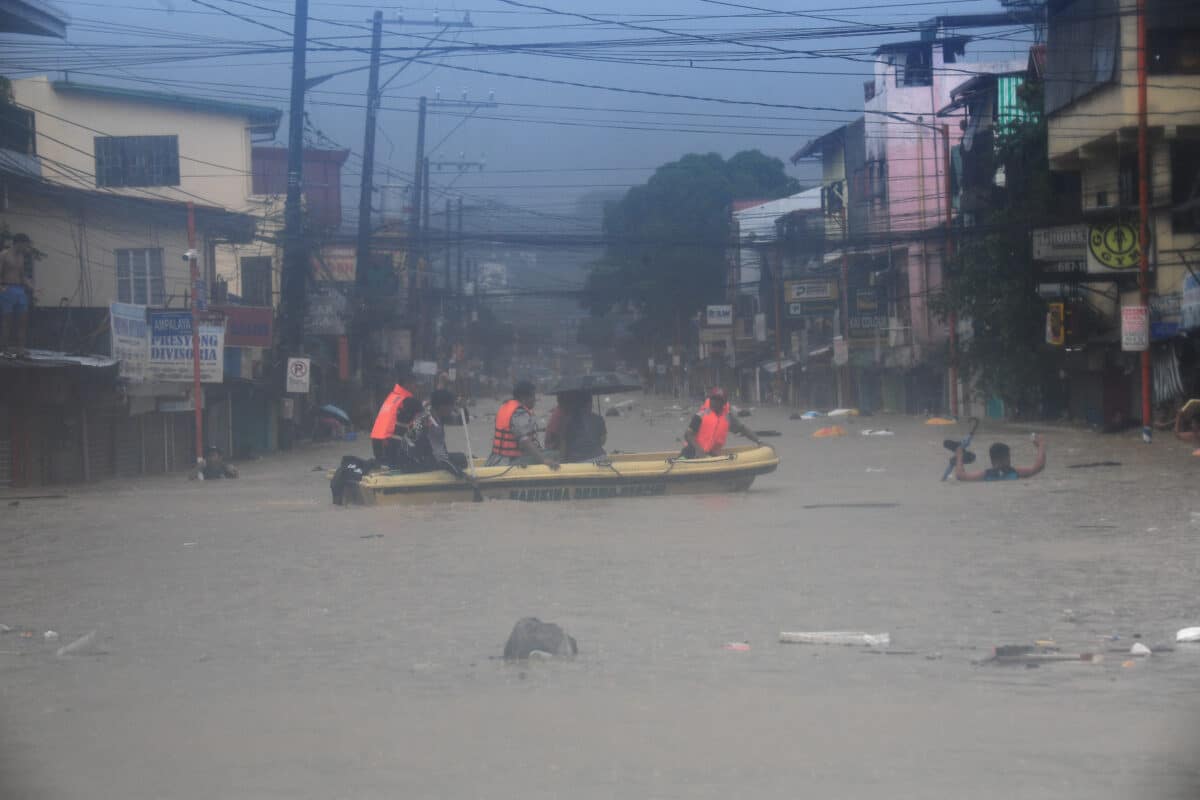 Rescuers ride on their boat as they evacuate residents from their flooded homes in Tumana village, Marikina City, east of Manila on July 24, 2024, amid heavy rains brought about by Typhoon Carina.