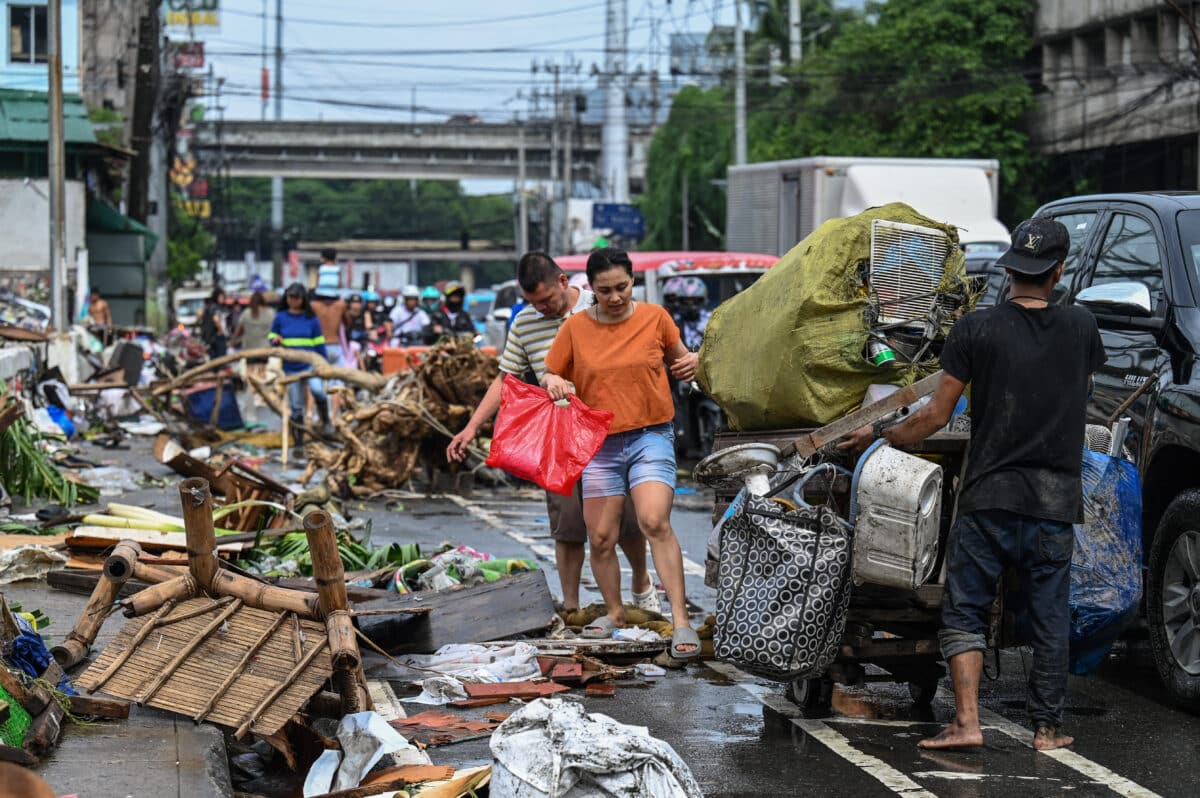 Residents walk past debris in the aftermath of Typhoon Gaemi in Manila