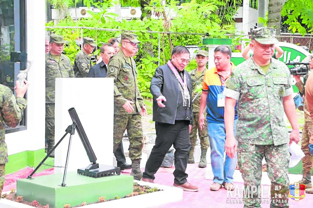 Maguindanao del Norte Gov. Abdulraof Macacua passes by a deactivated mortar that he, as a former Moro combatant, had to deal with as aguerrilla. In the right photo below, a child pretends to be an artillery spotter while touring the museum. 