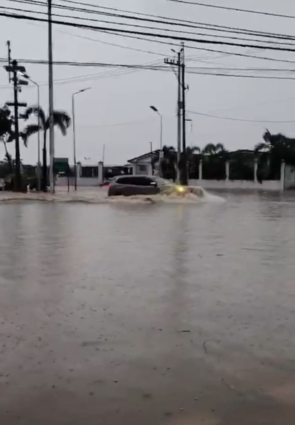 A sports utility vehicle breezes through the floods.