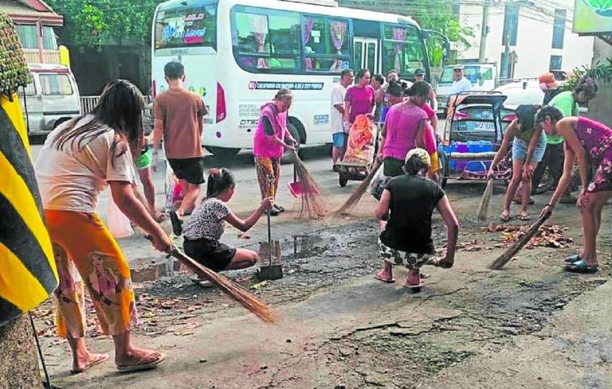 Iloilo City residents conduct a communitycleanup drive on Aug. 25 as part of the local government’s intensified campaign against dengue, particularly to destroy potential mosquito breeding sites. 