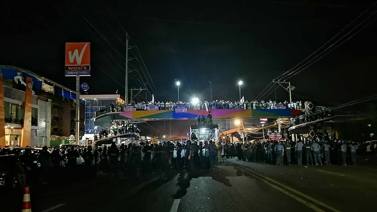 Antiriot policemen stand guard outside the KOJC compound in Buhangin District, Davao City where sect members hold a rally on Sunday night. JOSELLE R. BADILLA