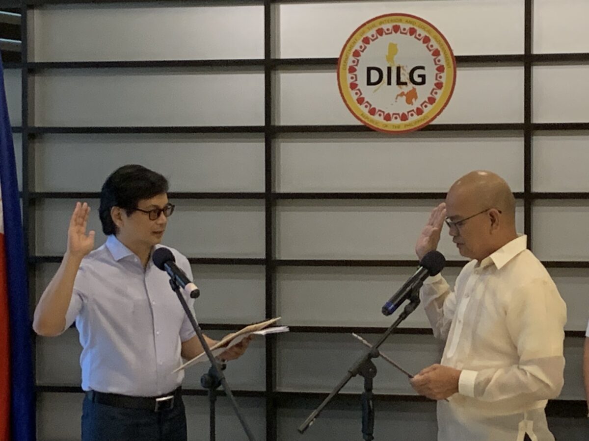 Bamban town councilor Erano Timbang (right) takes oath before Interior chief Benjamin Abalos Jr. (left) as he assumes mayoralty post temporarily, replacing former mayor Alice Guo who was dismissed by Ombudsman over Philippine offshore gaming operator  links. INQUIRER.net/John Eric Mendoza 