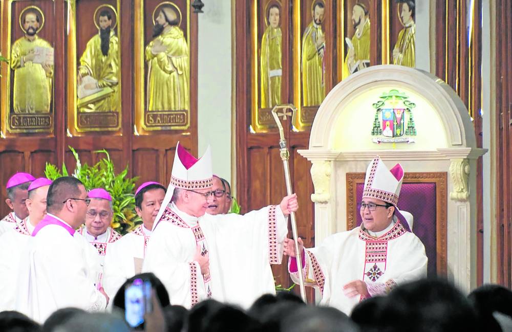 LEADING THE FLOCK Bishop Rafael Cruz (right) receives from Archbishop Charles John Brown, the Apostolic Nuncio to the Philippines, the crosier or pastoral staff as he is installed as thirdbishop of the Diocese of Baguio on Tuesday. 