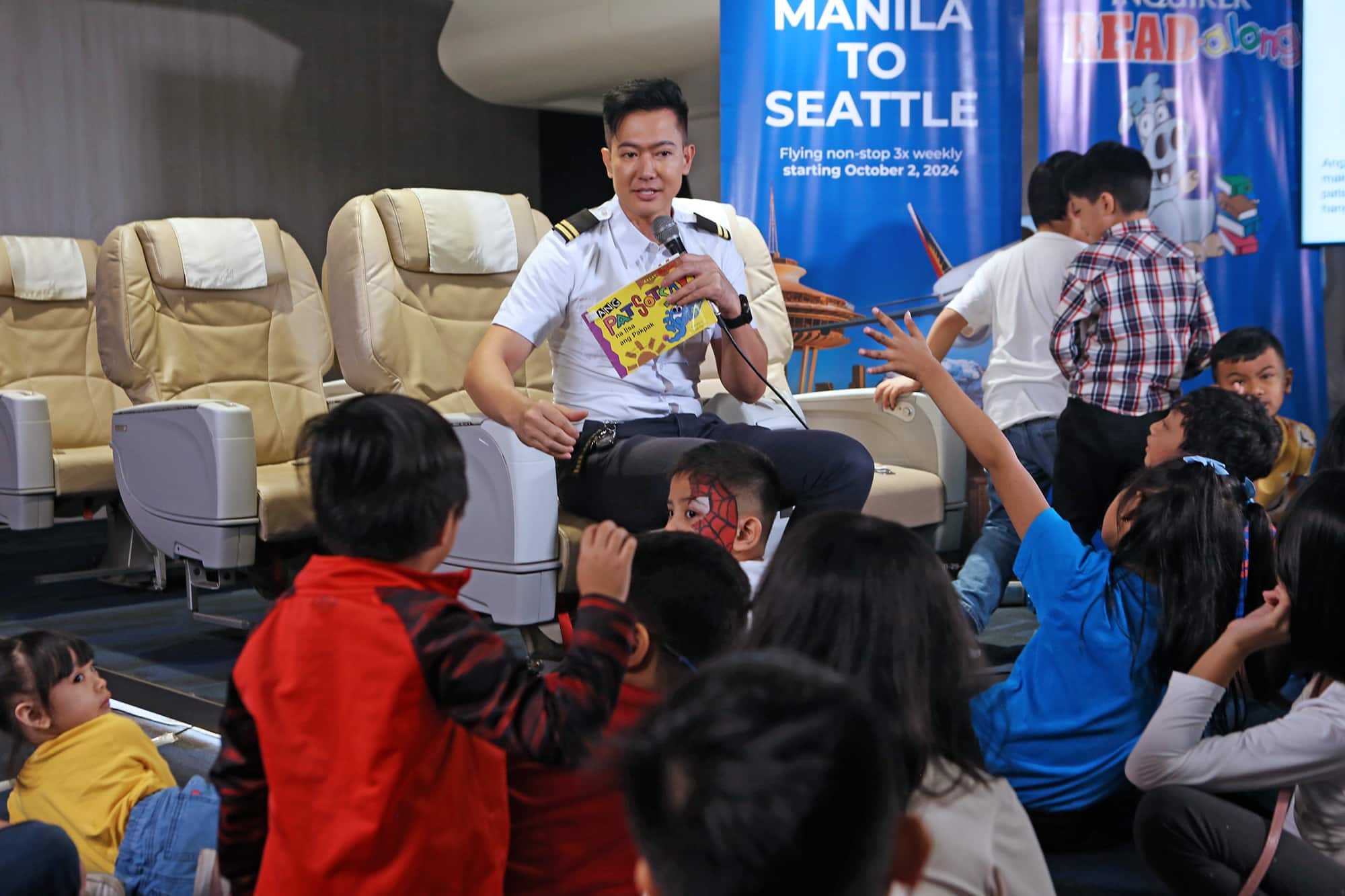 READING PAL Ronnie Liang, guest celebrity reader,recording artist and also a licensed pilot, reads a story to children during the Inquirer Read-Along session at the Philippine Airlines Museum in Pasay City.