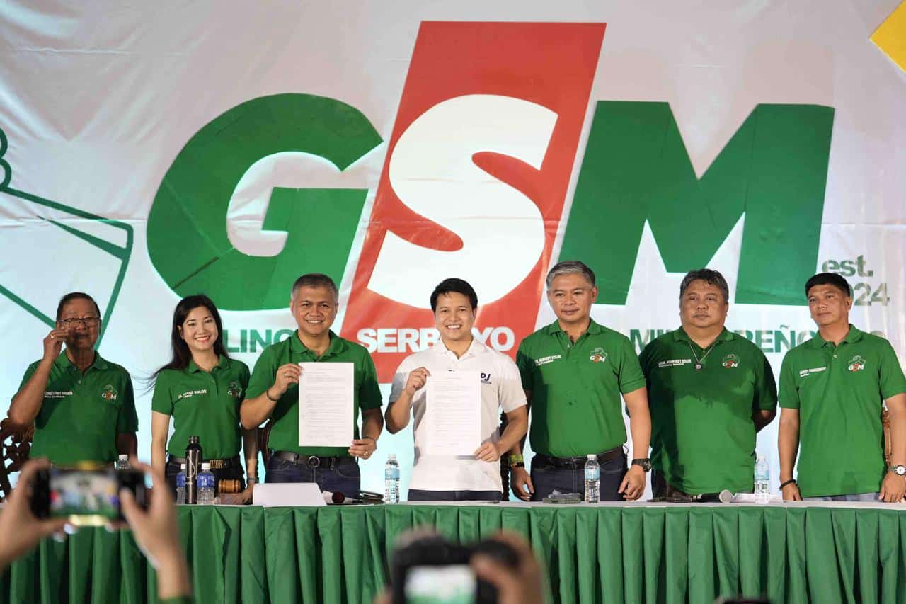 Governor Bonz Dolor and FPJ Panday Bayanihan Chairman Brian Poe-Llamanzares hold up papers declaring the partnership between GSM and FPJ Panday Bayanihan