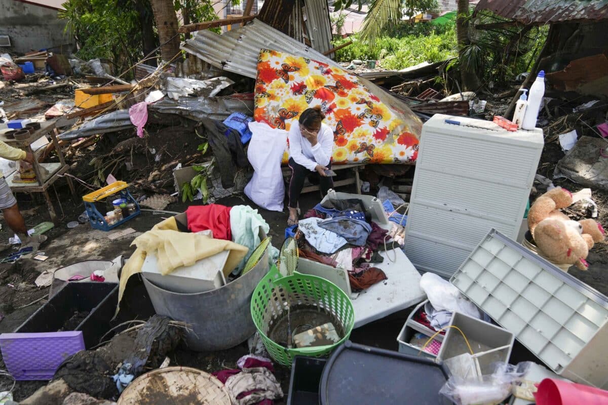 A resident sits beside belongings from their damaged home after a recent landslide triggered by Tropical Storm Trami struck Talisay, Batangas province, Philippines leaving thousands homeless and several villagers dead on Saturday, Oct. 26, 2024.