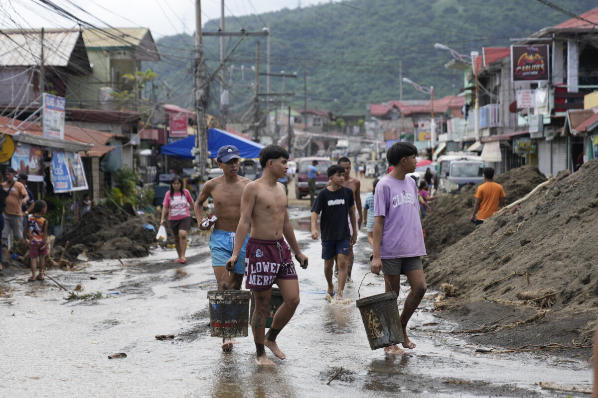 Residents clear out mud from their homes after a recent landslide triggered by Tropical Storm Trami struck Talisay, Batangas province, Philippines leaving thousands homeless and several villagers dead on Saturday, Oct. 26, 2024. 