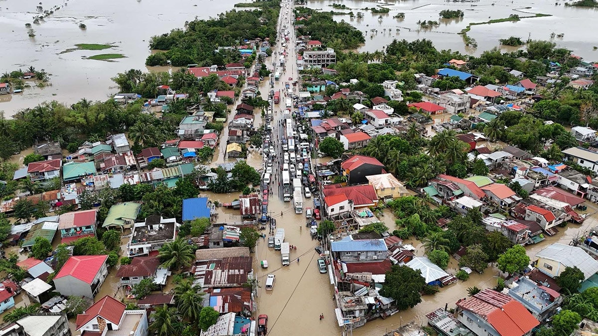 LONG WAIT Vehicles line up along Maharlika Highway in Camarines Sur as they wait for the floodwaters to subside, as seen in this drone shot in Milaor town at noon on Sunday. Only heavy vehicles, buses and trucks are allowed to travel on Saturday while light vehicles are still stranded due to floods. —PHOTO COURTESY OF CHINITONG MANLALAKBAY