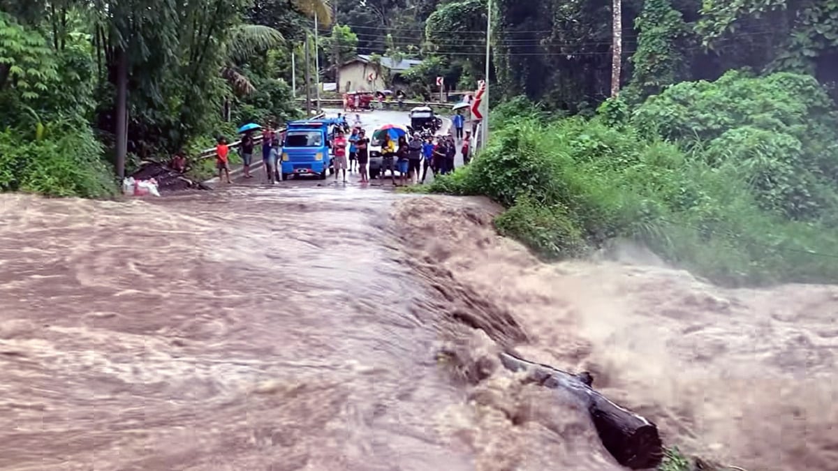 STOPPED Commuters are stopped by rampaging floodwater that swamped a road at Barangay Batasan in Makilala, Cotabato, on Tuesday morning amid heavy rains dumped by Tropical Storm “Kristine.” —FREDERICK GOZON/CONTRIBUTOR