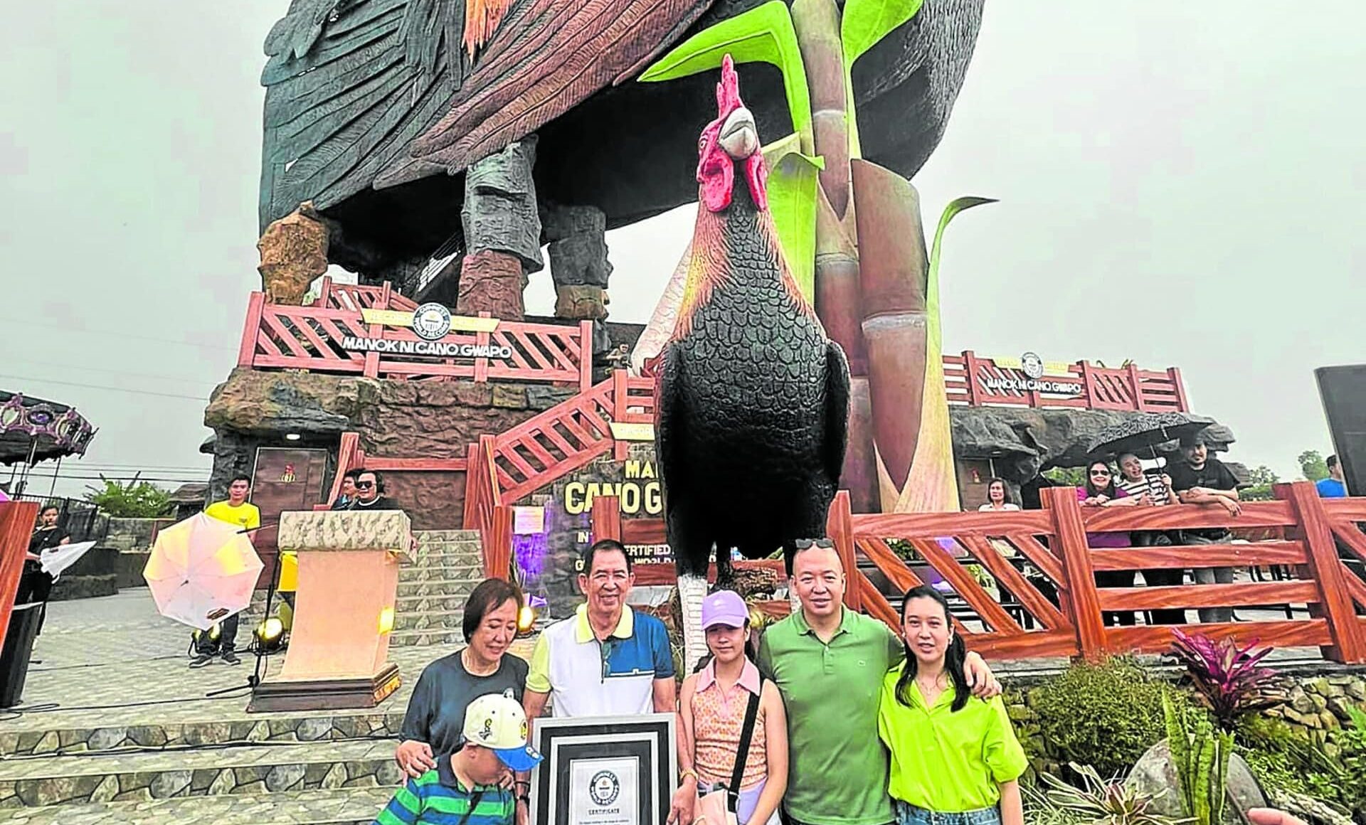 THE CHICKEN THAT LETS YOU CHECK IN Resort owner Ricardo“Cano” Tan and family show the Guinness World Records plaque they received on Saturday for the cocky feat of architecture behind them. 