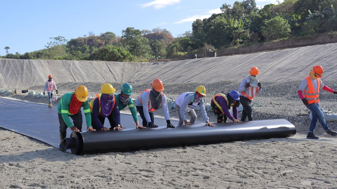 MAINTENANCEWORK In this photo taken in January,workers roll out a sheet of protective covering on the Kalangitan Sanitary Landfill’s expanded disposal area. 