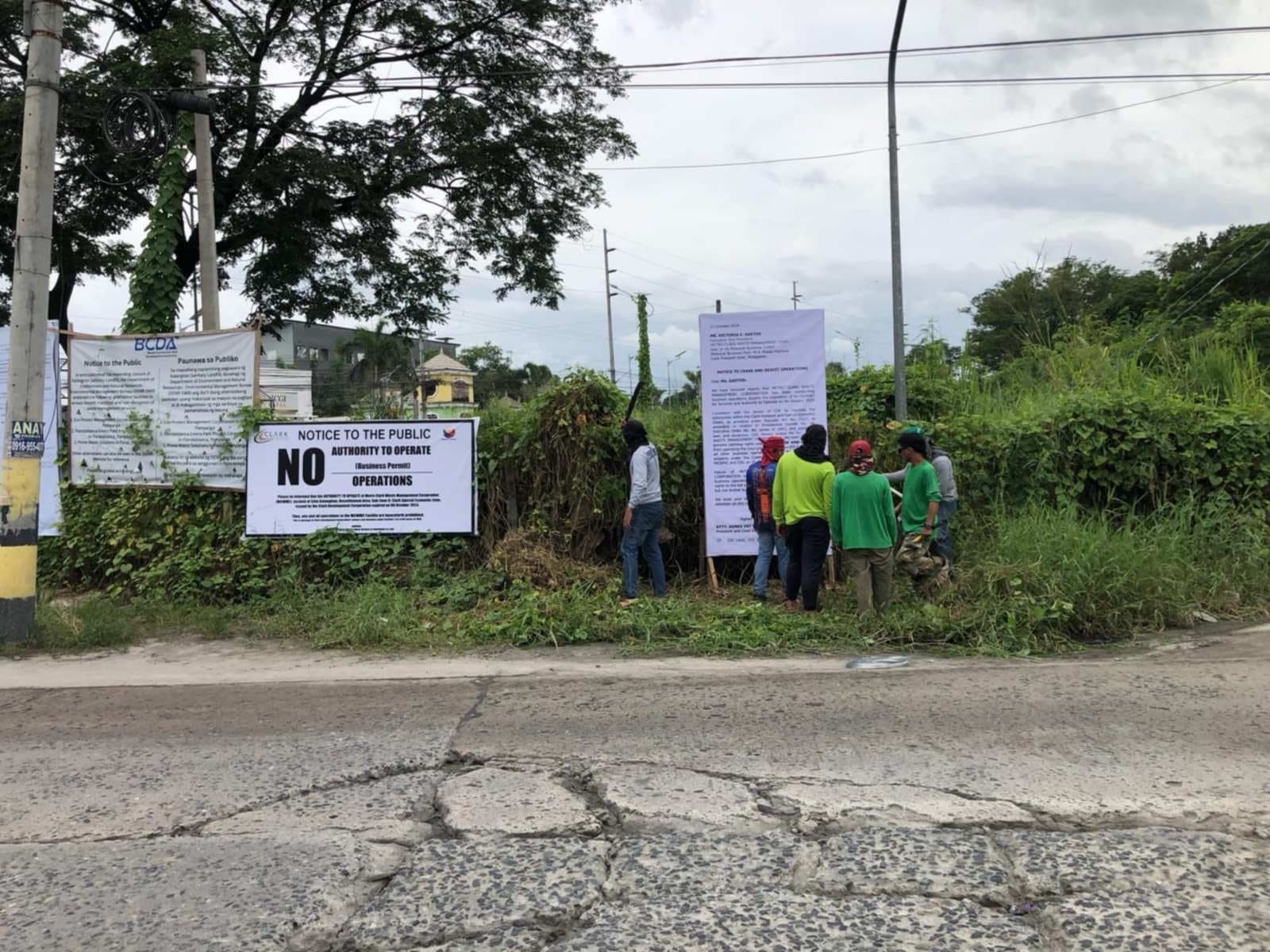 CLOSURE NOTICE Workers from the Clark developmentCorporation install on Tuesday, Oct. 29, notices along the road towards the Kalangitan landfill in Capas, Tarlac, stating that the Metro Clark Waste Management Corporation (MCWMC) no longer have a business permit and authority to operate the waste disposal facility. On the same day, however, a Capas court grants an injunction sought by MCWMC that stops the closure of the facility.