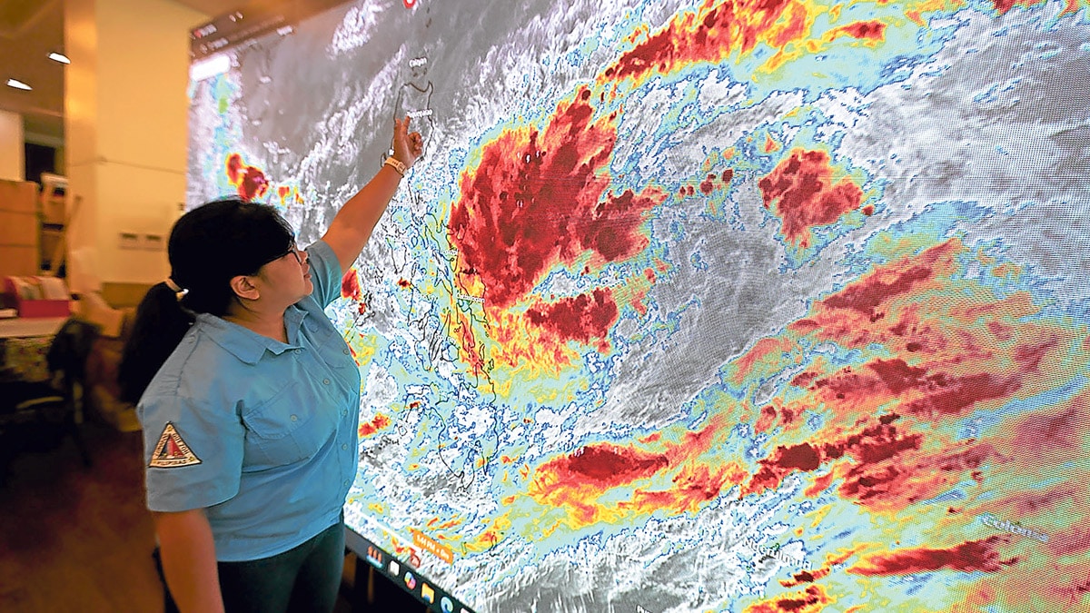 TRACKING ‘KRISTINE’ Aleandra Rivera, weather unit supervisor of the Quezon City Disaster Risk Reduction and Management Office, checks the general location of Tropical Depression “Kristine” on Monday, as the state weather bureau raised Tropical Cyclone Wind Signal No. 1 in at least 17 provinces across the country. 